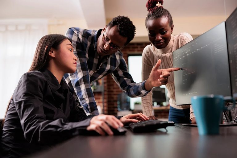 A team gathered around a screen, working together.